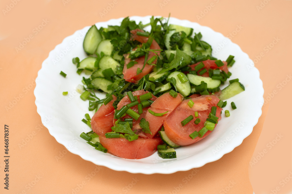 salad of tomatoes and cucumbers with herbs on a white plate salad of tomatoes and cucumbers with herbs on a white plate