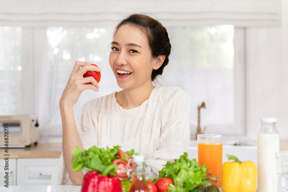 Beautiful smiling healthy woman with tomato in her hands while preparing vegan food. Proper nutrition. Beautiful smiling healthy woman with tomato in her hands while preparing vegan food. Proper nutrition.