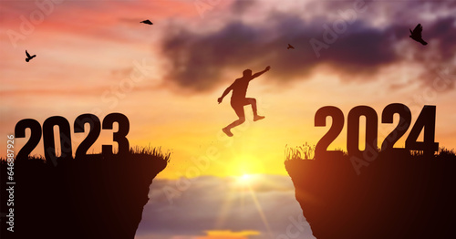 Man silhouette jumping on cliff 2023 over the precipice at amazing sunset. New Year's concept. Vector of starting and welcome happy new year 2024. People enters the year symbol 2024, creative idea.
