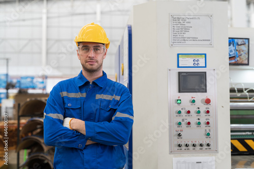 Male electrician engineer maintenance electric system in industry factory. Factory male worker at work in the industry factory, work with CNC machine. Factory engineer male worker maintaining machine