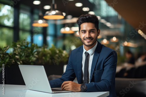 Young businessman or corporate employee using laptop at office