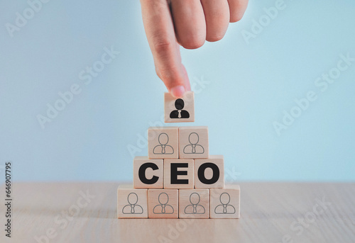 Hand selected leader wooden block Cube with CEO Business team concept indicating the direction of movement towards the goal. Businessmen standing together as a team