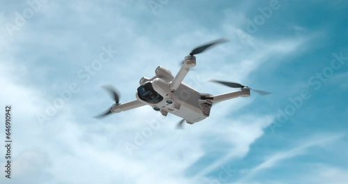 Drone Copter is filming in air. Modern quad copter drone on sky background. The concept of filming video and photos while traveling on quadcopter drone. Modern robot drone in slow motion