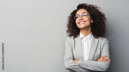 Happy youthful confident professional business woman, pretty trendy female executive looking at camera, standing arms crossed on gray background photo
