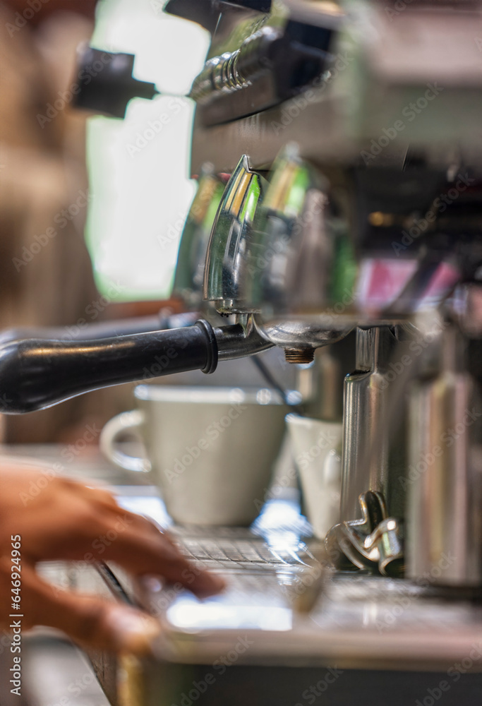 cafeteria barista preparing an espresso shot at the coffee machine at the bar