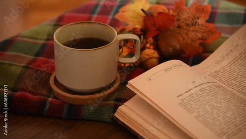Turning the pages of a book in a cozy autumn decor with candles 