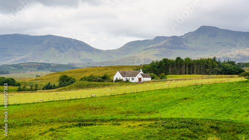 Green landscape of mountains with sheep farms on the Isle of Skye, Scotland.