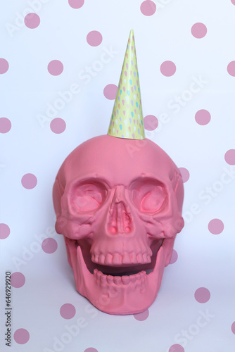 pastel pink skull with a colorful party hat and a dotty background