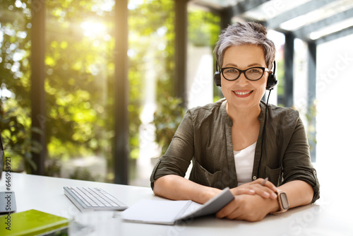 Attractive mature lady have video conference with client at office