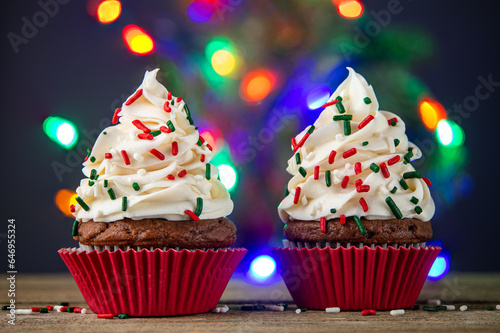 Cupcake. Cupcakes and Christmas Tree. Merry Christmas. Red cup liners. Tasty baking cupcakes, cake or muffin with white cream icing, frosting and colored sprinkles. Homemade bakery, confectionery shop