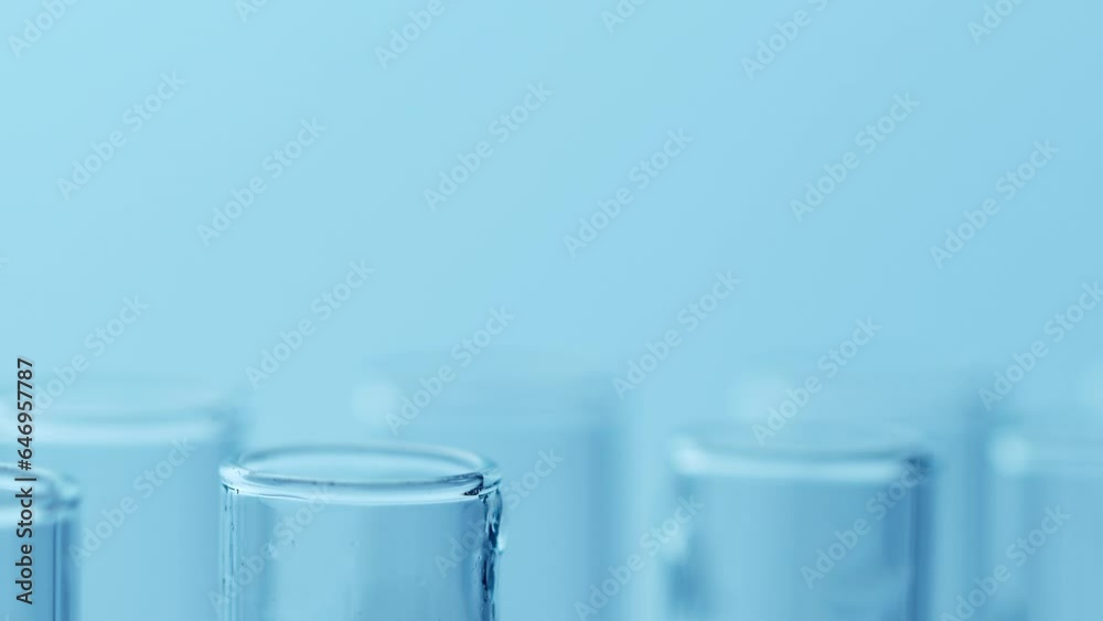 Pipette drip drops into laboratory test glass tubes, nobody. Closeup. Blue tone Pipette drip drops into laboratory test glass tubes, nobody. Closeup. Blue tone