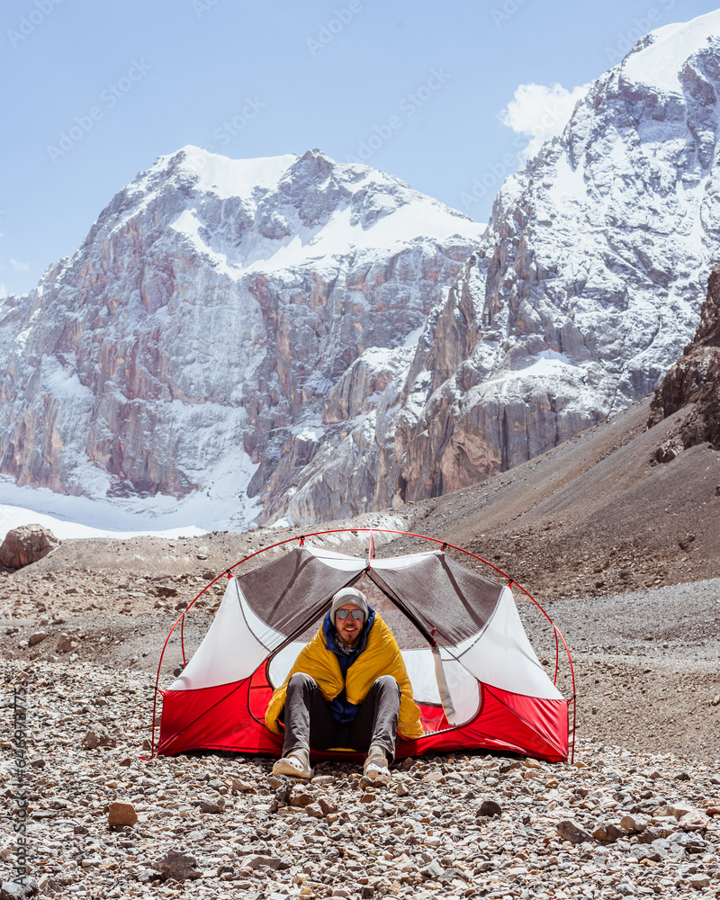 A hiker in a tent camp among the mountains in Tajikistan