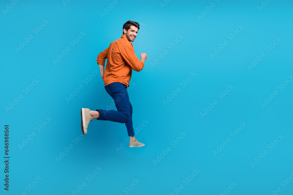 Full length profile rear photo of overjoyed cheerful person jumping rush empty space isolated on blue color background