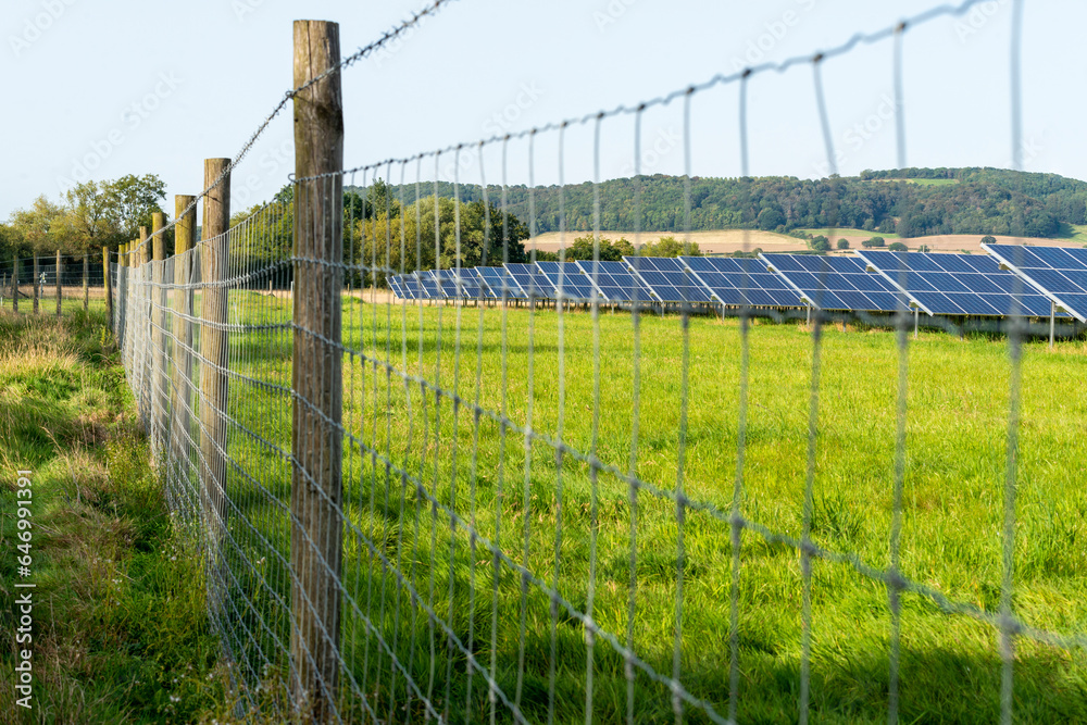 Solar Farm panels,surrounded by security fence, the Cotswolds aea, rural Gloucestershire,England,United Kingdom.