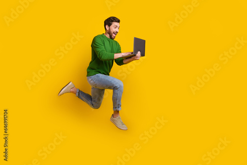 Full size body photo of young crazy business worker web developer professional programmer running jump isolated on yellow color background