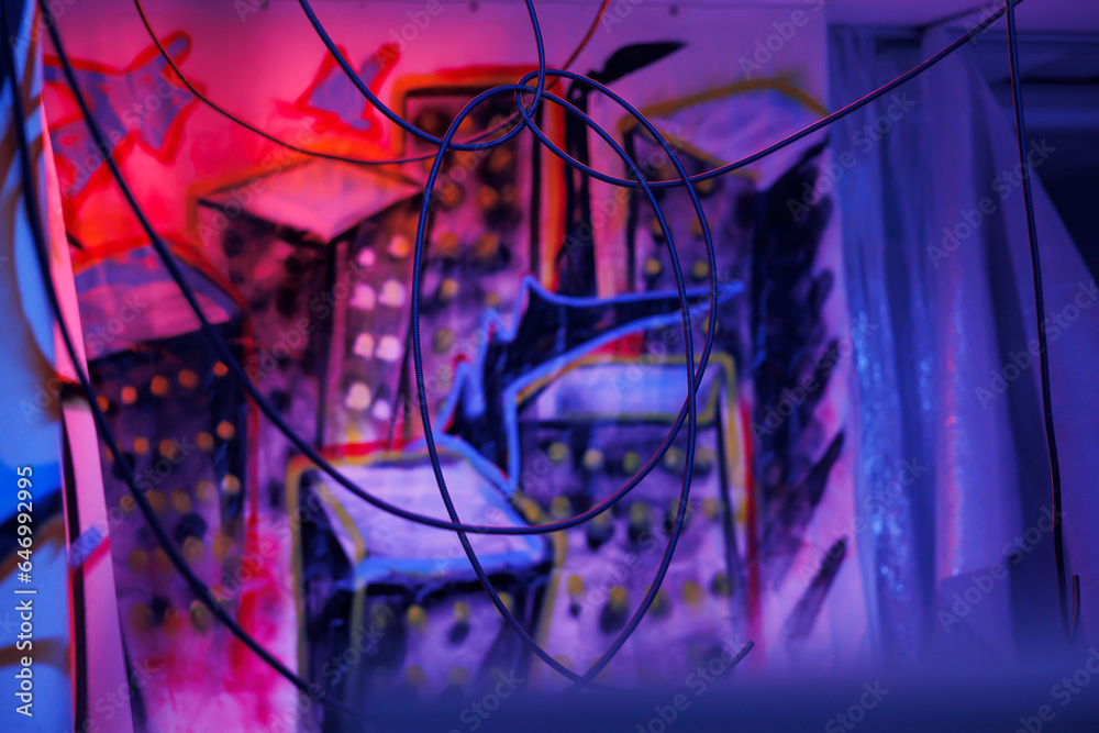 Obraz premium Damaged old place with fluorescent neon lights and dust on walls with graffiti art, warehouse with crumbling structure covered in messy artwork. Old abandoned space with bright lights.