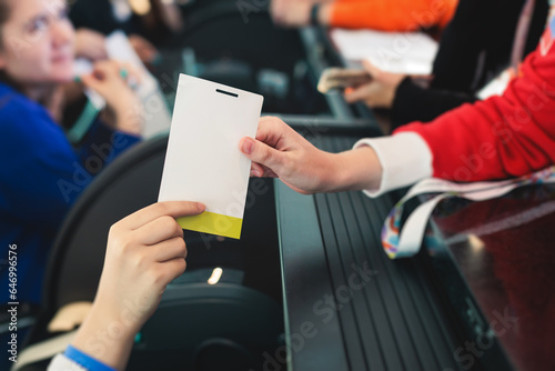 Process of checking in on a conference congress forum event, registration desk table, visitors and attendees receiving a name badge and entrance wristband bracelet and register electronic ticket