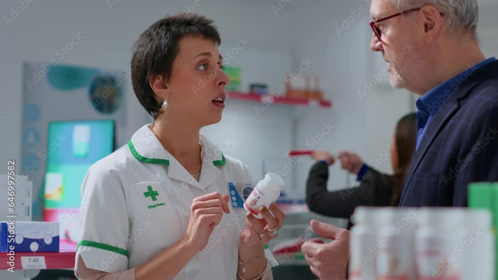 Qualified pharmacist in chemist shop offering patient heart arrhythmia medication pills to treat disease symptoms. Aged man receiving heart attack prevention drug from drugstore worker Qualified pharmacist in chemist shop offering patient heart arrhythmia medication pills to treat disease symptoms. Aged man receiving heart attack prevention drug from drugstore worker
