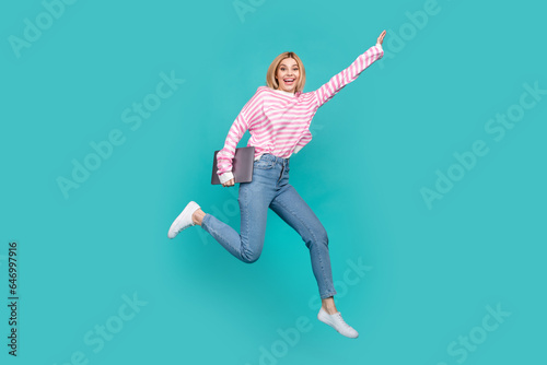 Full length photo of shiny pretty girl dressed striped sweater holding modern gadget jumping high isolated teal color background