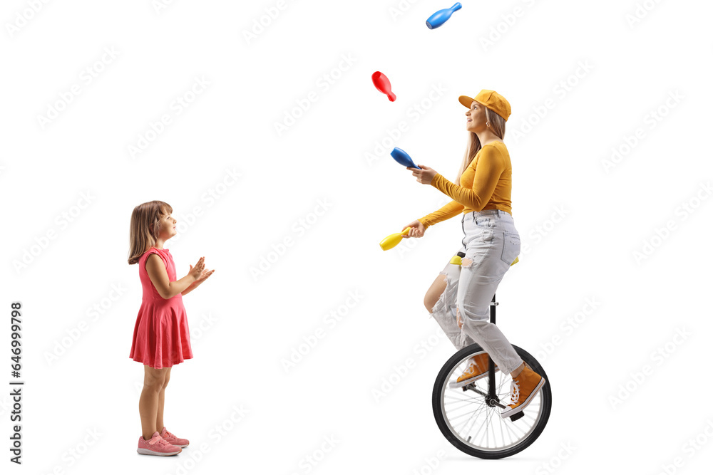 Little girl watching a young female riding a unicycle and juggling Little girl watching a young female riding a unicycle and juggling