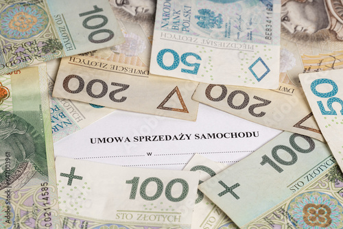 Car sales contract, an inscription surrounded by Polish PLN banknotes (selective focus)