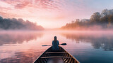 Person Canoeing Through a Misty Lake at Dawn