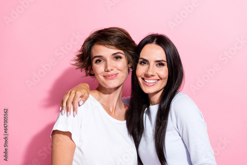 Photo of two positive nice cute girls dressed white outfit hugging together isolated on pink color background