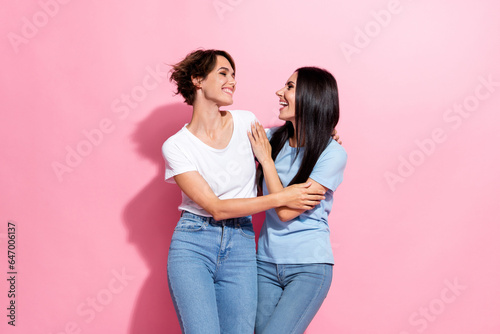 Full body photo of two young relatives sisters joking have fun good mood wear denim jean new t shirts isolated on pink color background