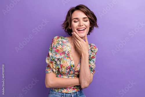 Photo portrait of lovely young lady touch chin laughing have fun wear trendy flower print garment isolated on violet color background