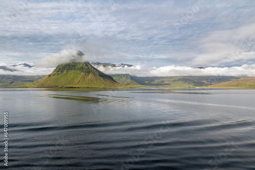 Kirkjufell at the coast entrance Grudarfjordur, Iceland with mountains and clouds in the background arriving by ship photo