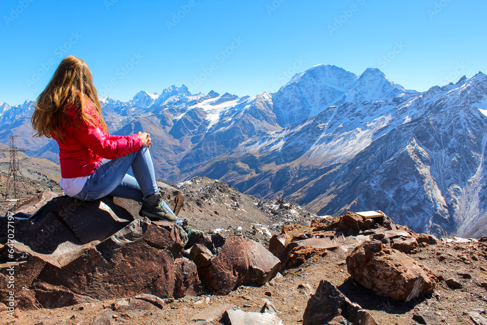 Naklejka premium The girl with bright red hair overlooking the mountains, Russia