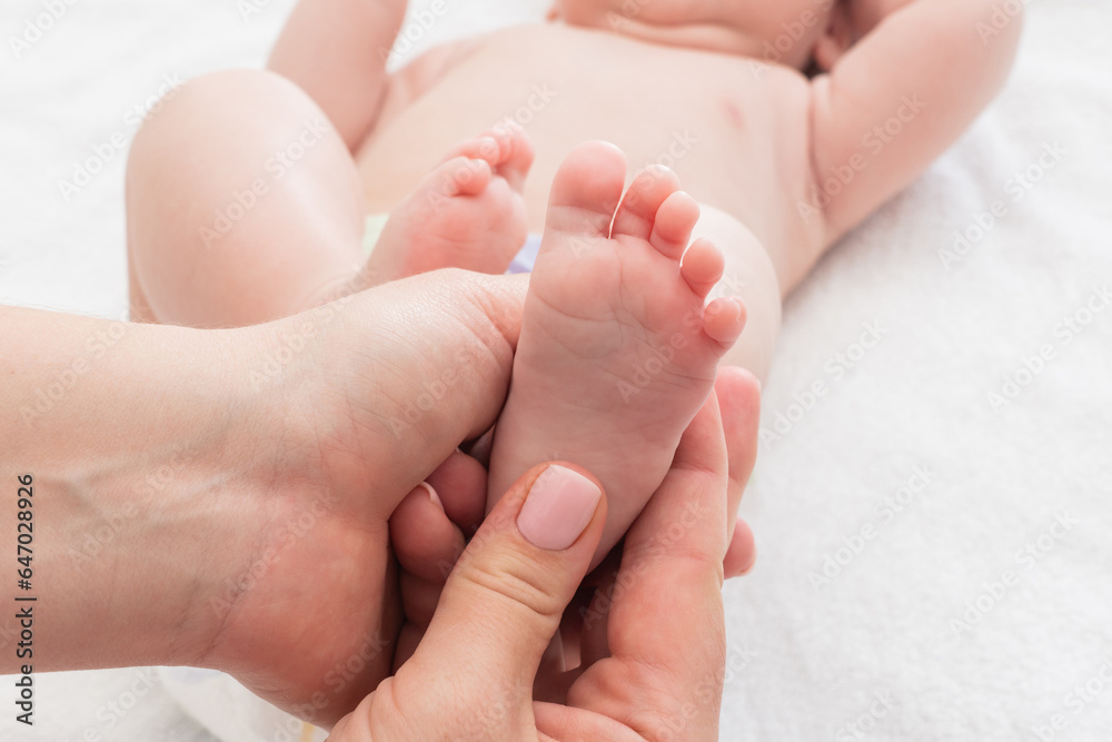 Gentle touch on newborn's delicate feet, Concept of maternal massage techniques Gentle touch on newborn's delicate feet, Concept of maternal massage techniques
