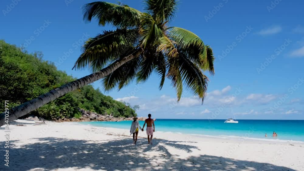 Anse Georgette Praslin Seychelles, a young couple of men and women on a tropical beach during a luxury vacation in Seychelles. Tropical beach Anse Lazio Praslin Seychelles