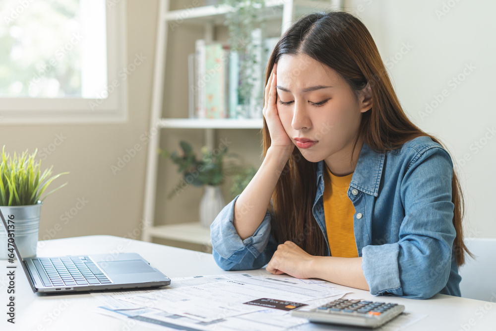 Financial owe asian woman sitting stressed by calculate expense at home, looking at invoice or bill, have no money to pay, mortgage or loan. Debt, bankruptcy or bankrupt concept Financial owe asian woman sitting stressed by calculate expense at home, looking at invoice or bill, have no money to pay, mortgage or loan. Debt, bankruptcy or bankrupt concept