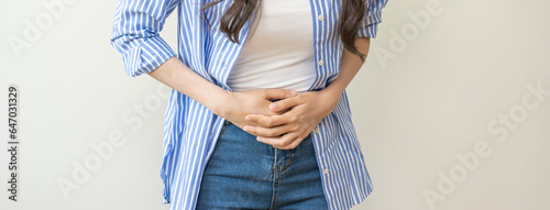 Flatulence asian young woman intolerance hand in stomach ache, suffer from food poisoning, abdominal pain and colon problem, gastritis or diarrhoea when at home. Patient belly, abdomen or inflammation photo
