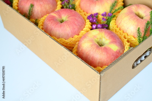 beautiful pink apple in the box on light blue background