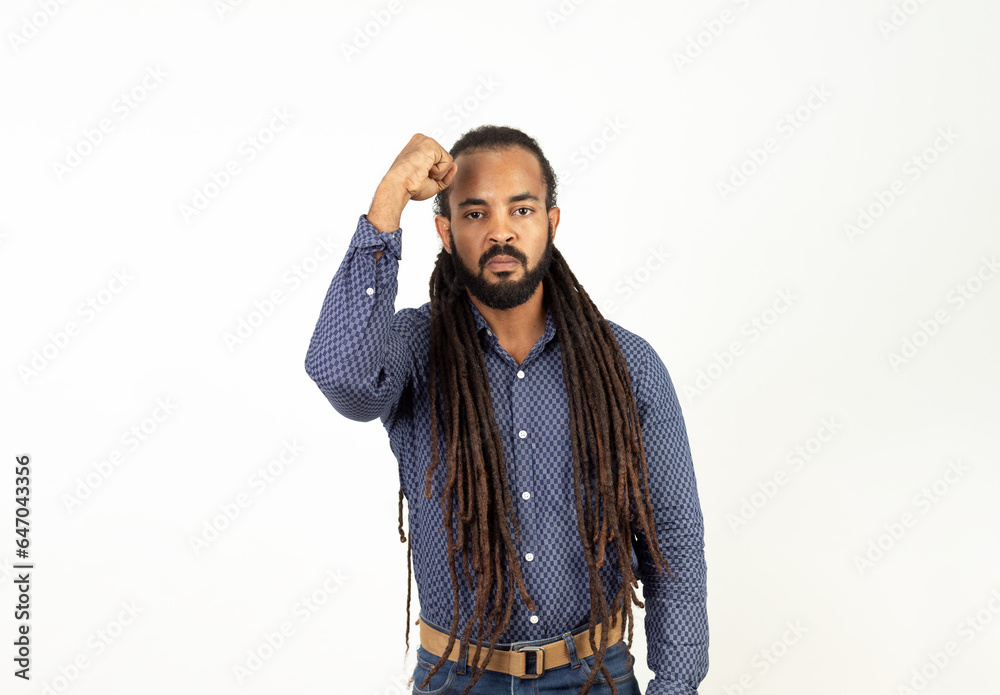 Latino Man with Rasta Hair, dreadlocks on White Background with Copy Space and Raised Fist Symbolizing Anti-Racism Latino Man with Rasta Hair, dreadlocks on White Background with Copy Space and Raised Fist Symbolizing Anti-Racism