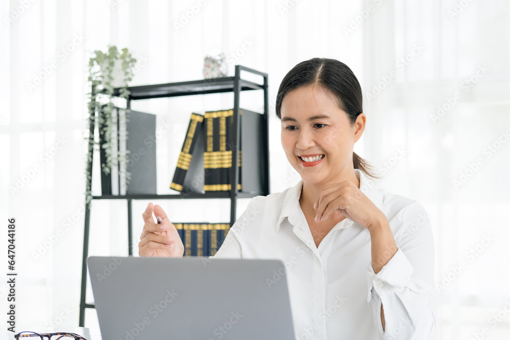 Asian female entrepreneur working remotely from home office using modern computer.Young cheery happy positive cute beautiful business woman sit in home office using laptop computer... Asian female entrepreneur working remotely from home office using modern computer.Young cheery happy positive cute beautiful business woman sit in home office using laptop computer...