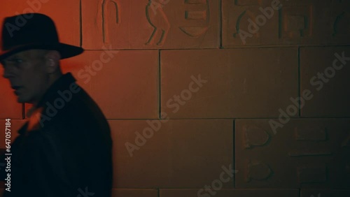 Adventurer explorer treasure hunting exploring an Egyptian or Aztec tomb in a temple with a blazing flame torch on fire