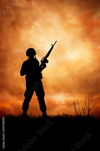 silhouette of a soldier on a hill with a gun