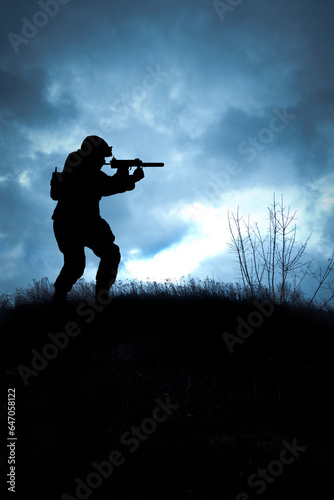 silhouette of a soldier on a hill with a gun