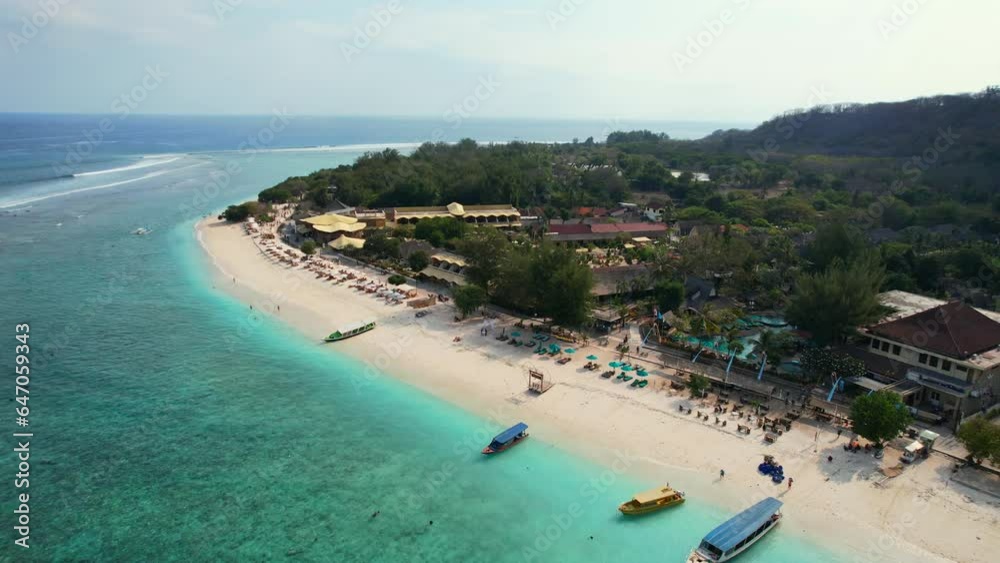 Parallax of Gili Trawangan Island Soft Sand Public Beach Coast with Idyllic Turquoise Sea and Travel Tour Boats Moored in Lombok Indonesia, establishing aerial shot Parallax of Gili Trawangan Island Soft Sand Public Beach Coast with Idyllic Turquoise Sea and Travel Tour Boats Moored in Lombok Indonesia, establishing aerial shot