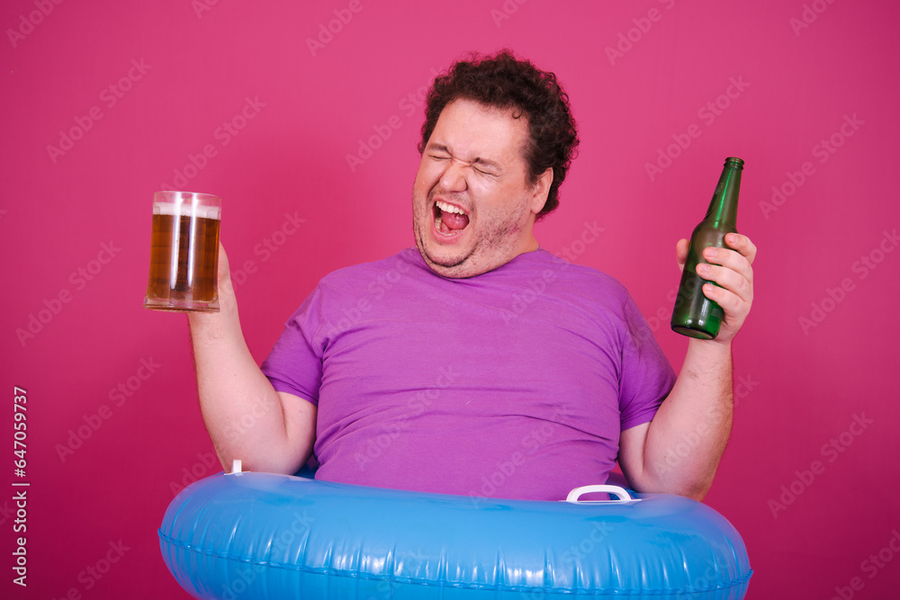 Vacations and holidays. Funny fat man with an inflatable ring posing on a pink background.