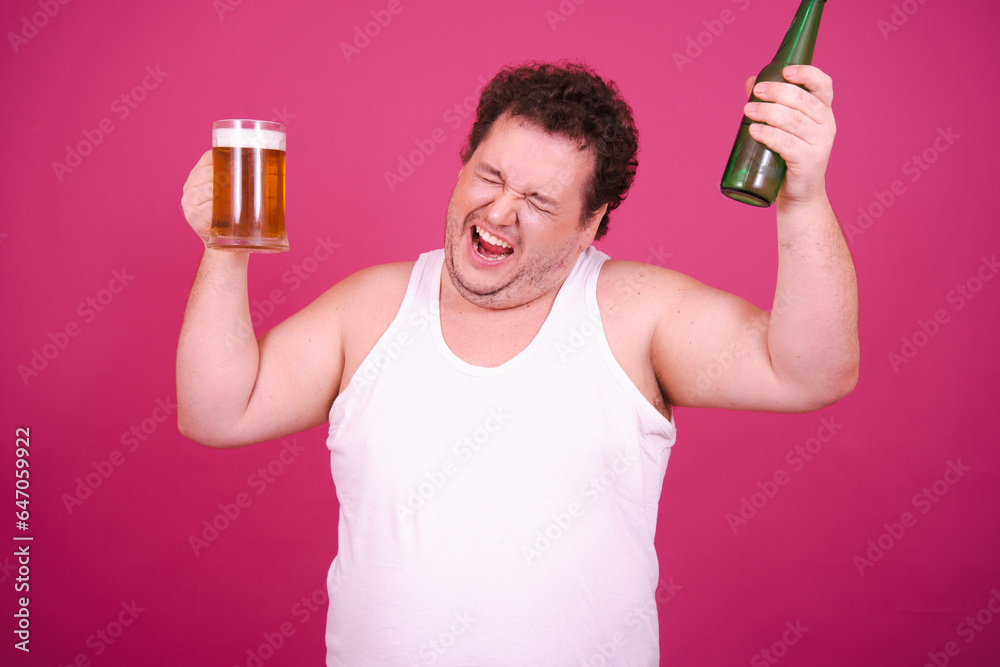 Drunk fat man posing on a pink background. Alcohol and a healthy lifestyle. Drunk fat man posing on a pink background. Alcohol and a healthy lifestyle.