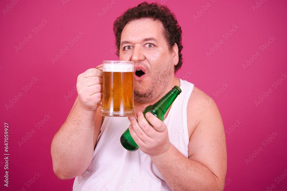 Drunk fat man posing on a pink background. Alcohol and a healthy lifestyle. Drunk fat man posing on a pink background. Alcohol and a healthy lifestyle.