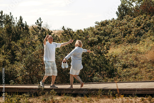 Emotional meeting of happy elderly man and woman on the path in the park