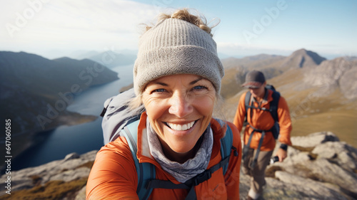Happy middle age woman hiking on the top of mountain © FATHOM