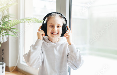 Cute little girl listening to music in headphones