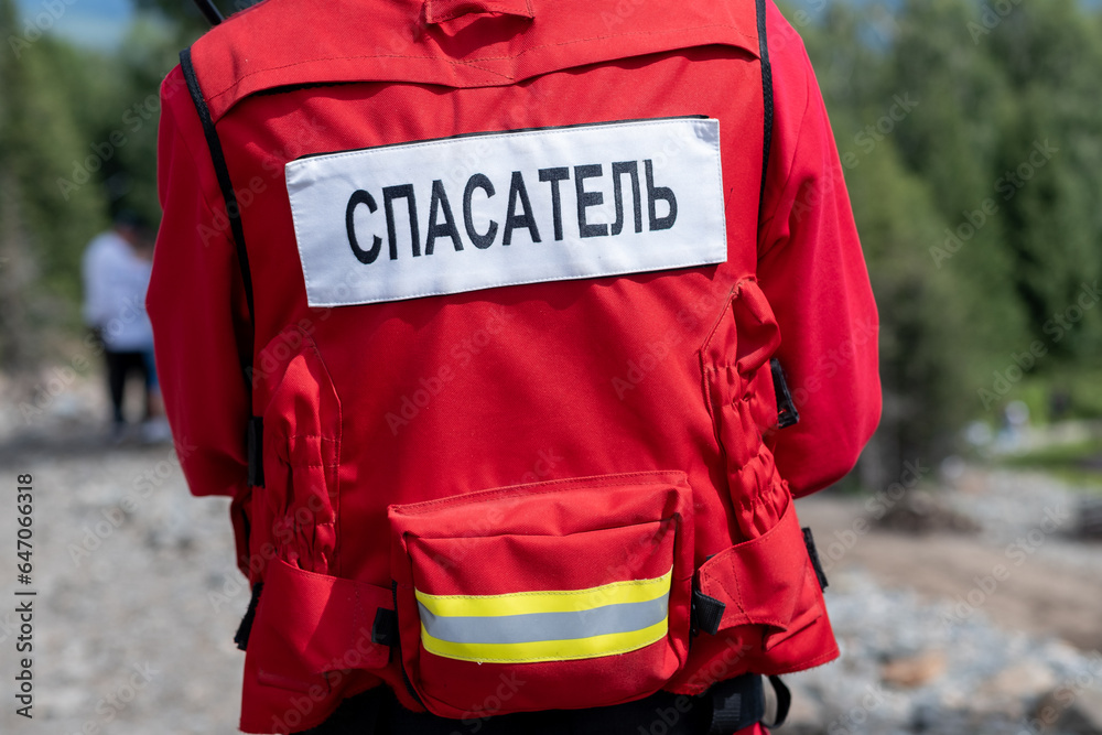 Rescuer in Russia in a uniform with the inscription on the back Rescuer. A man in a red jacket is ready to help in trouble and save lives. Rescuer in Russia in a uniform with the inscription on the back Rescuer. A man in a red jacket is ready to help in trouble and save lives.