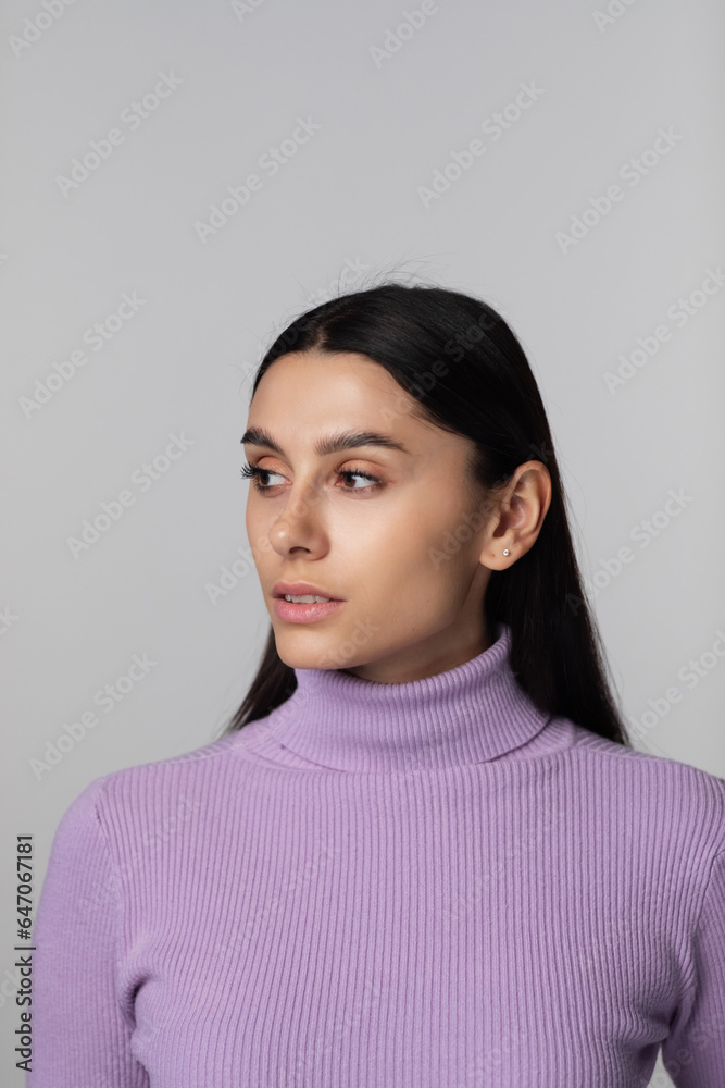 Fashion portrait of a woman looking at the camera on a gray background. Beautiful girl Fashion portrait of a woman looking at the camera on a gray background. Beautiful girl